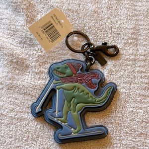 The classic logo of the COACH ( T- Rex)! It is a clip on/key chain!